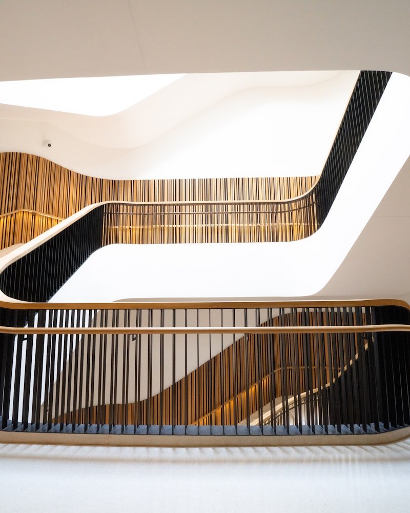 Sweeping curved staircases with slim iron pickets and warm wood handrails inside a bright Ottawa home